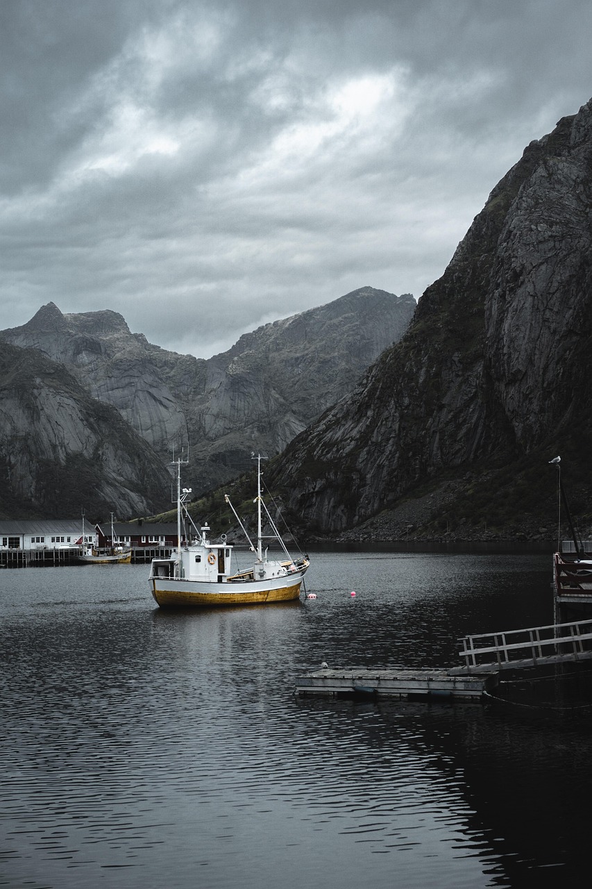 Generic small 12-guest expedition ship anchored in a quiet Svalbard fjord